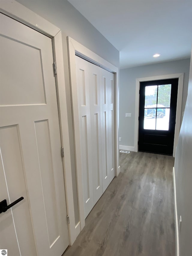 doorway with light wood-type flooring and baseboards