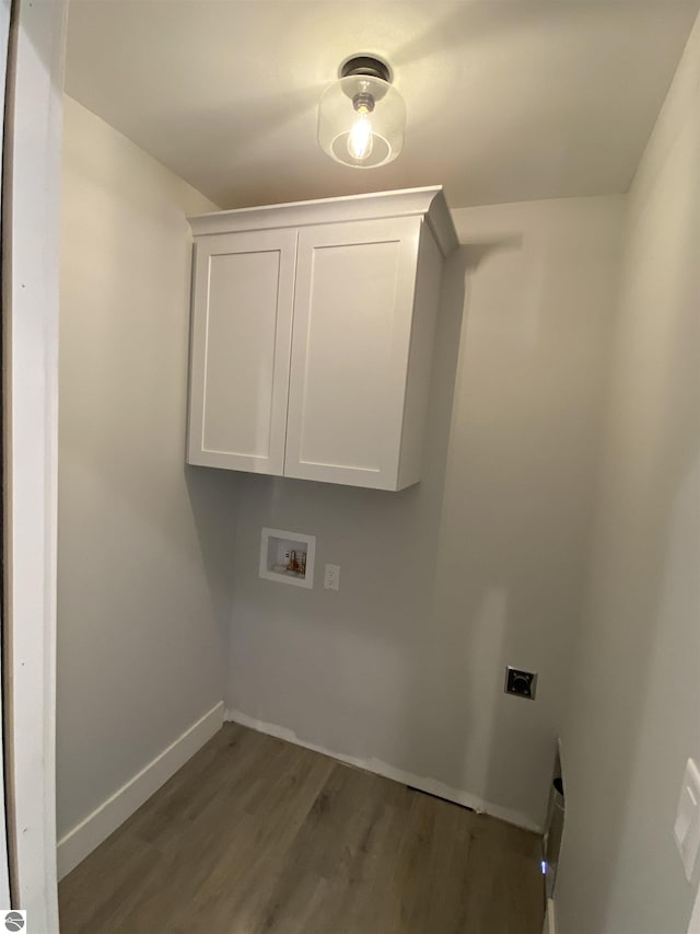 laundry room with dark wood-style floors, hookup for a washing machine, cabinet space, electric dryer hookup, and baseboards