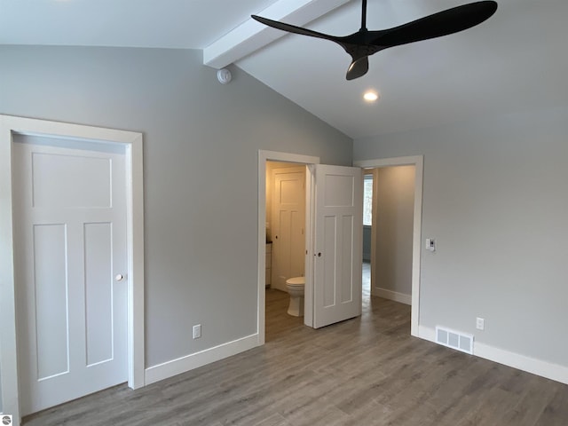 unfurnished bedroom featuring lofted ceiling with beams, wood finished floors, visible vents, and baseboards