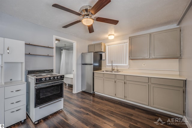 kitchen featuring white range with electric cooktop, dark wood-style flooring, freestanding refrigerator, light countertops, and a sink
