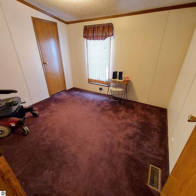 unfurnished bedroom with visible vents, lofted ceiling, crown molding, a textured ceiling, and carpet flooring