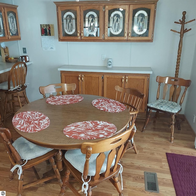 dining area featuring light wood-style flooring and visible vents