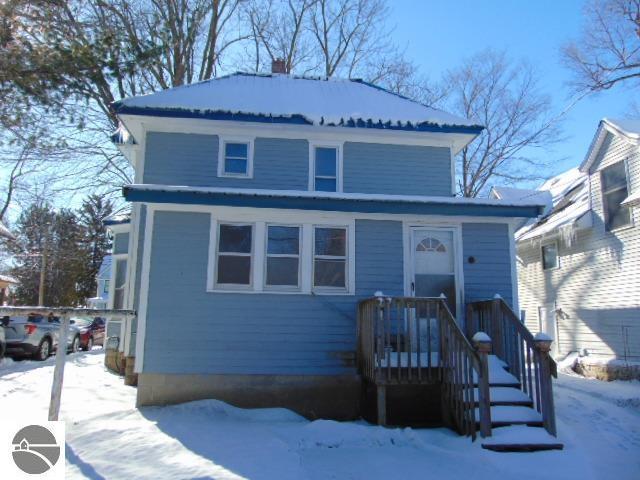 american foursquare style home featuring a chimney