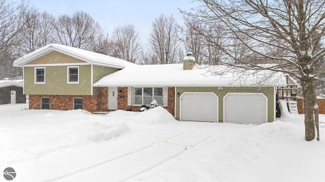 split level home featuring a garage, brick siding, and a chimney