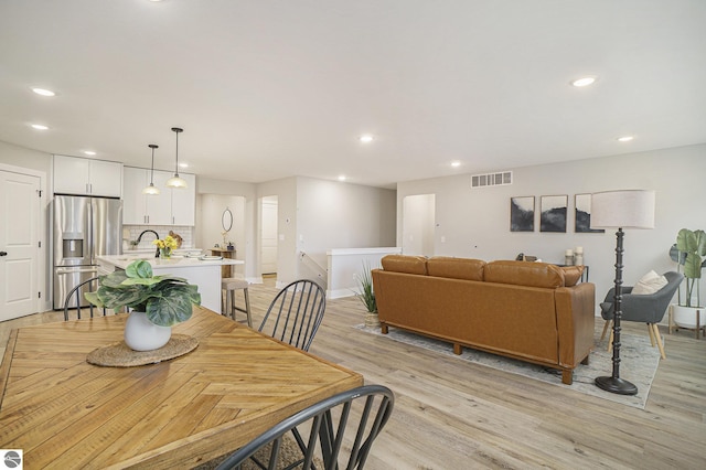 dining space with recessed lighting, visible vents, light wood-style flooring, and baseboards