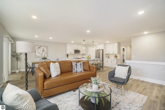 living area featuring light wood-style floors, recessed lighting, and baseboards