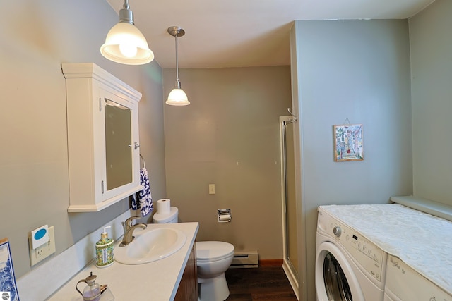 bathroom featuring a baseboard radiator, toilet, vanity, wood finished floors, and washer and dryer