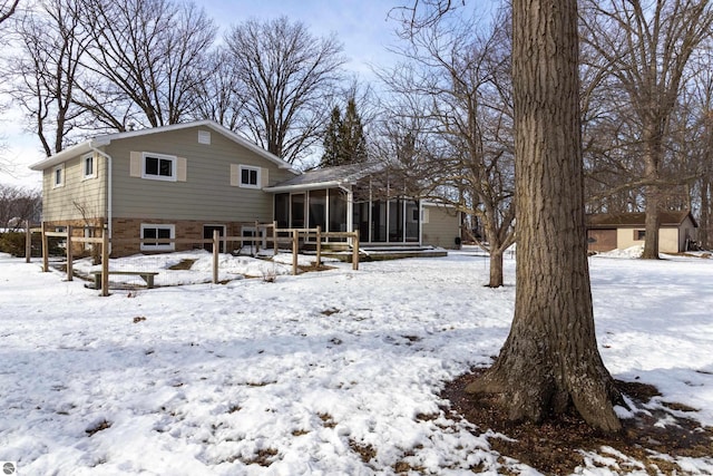 snow covered property with a sunroom