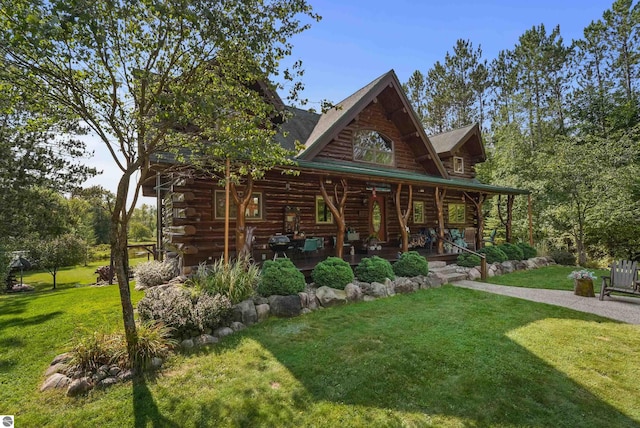 view of front of property featuring a front yard, covered porch, and log exterior