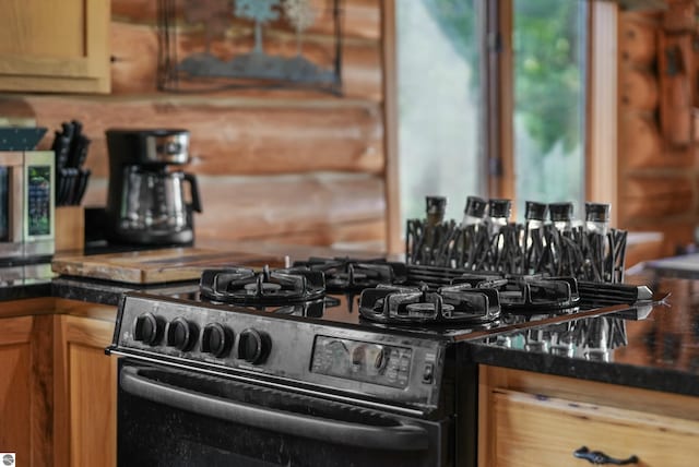 kitchen featuring black gas stove and stainless steel microwave