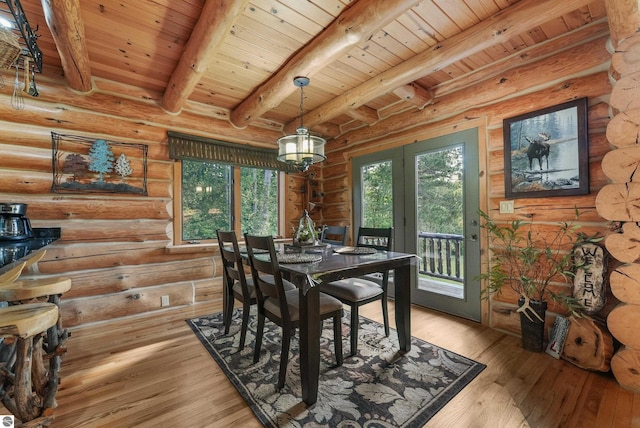 dining room featuring light wood-type flooring, a healthy amount of sunlight, wood ceiling, and beam ceiling