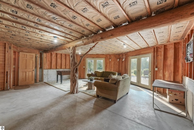 unfurnished living room featuring french doors and concrete floors