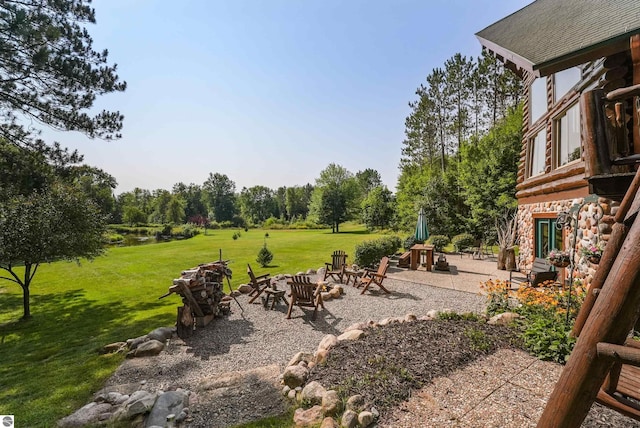 view of yard with a fire pit, playground community, and a patio