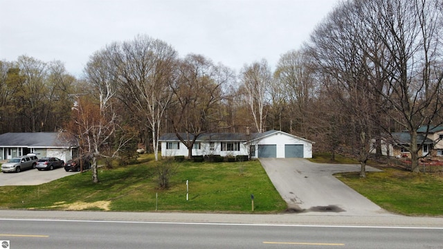 view of front of property featuring a garage, concrete driveway, and a front yard