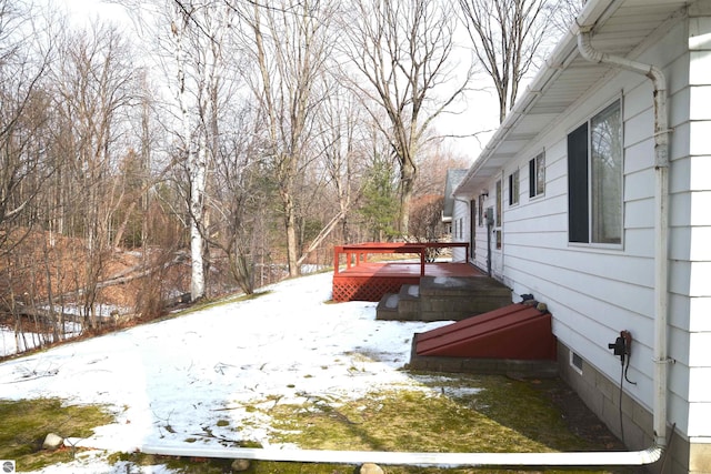 yard layered in snow featuring a deck