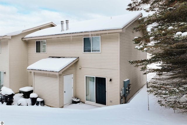 view of snow covered back of property