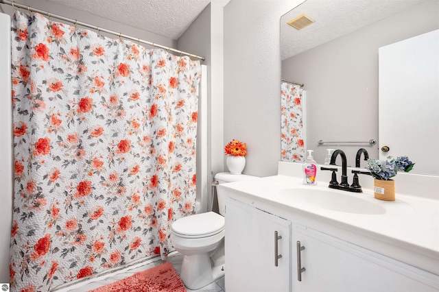 bathroom featuring a textured ceiling, toilet, vanity, and visible vents