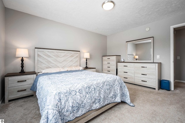 bedroom featuring light carpet, baseboards, and a textured ceiling