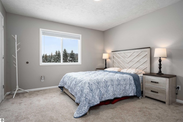 bedroom with light carpet, a textured ceiling, and baseboards