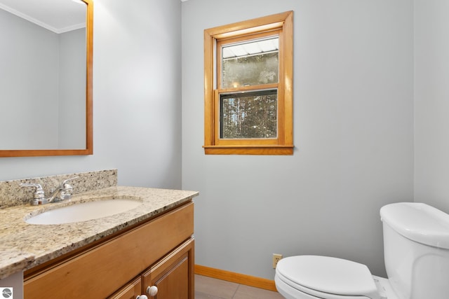 bathroom with crown molding, toilet, vanity, tile patterned flooring, and baseboards