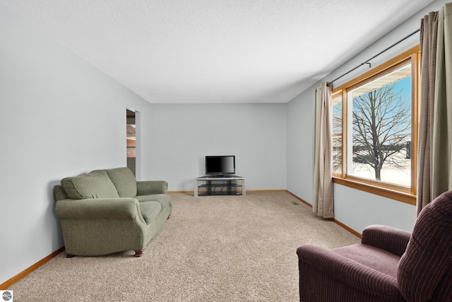 living area featuring light carpet, a textured ceiling, and baseboards