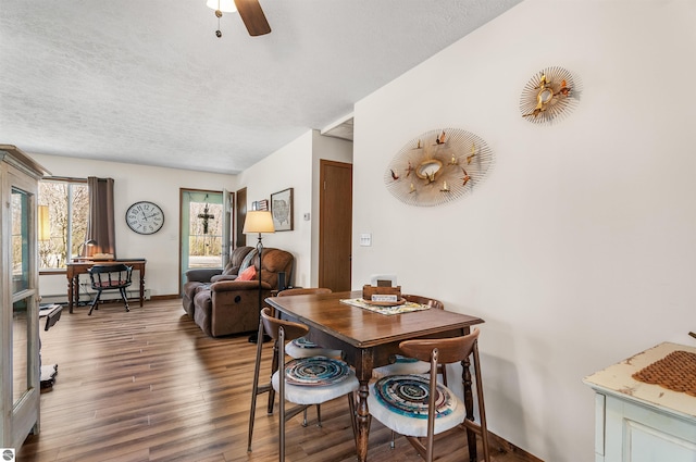 dining space featuring ceiling fan, a textured ceiling, baseboards, and wood finished floors