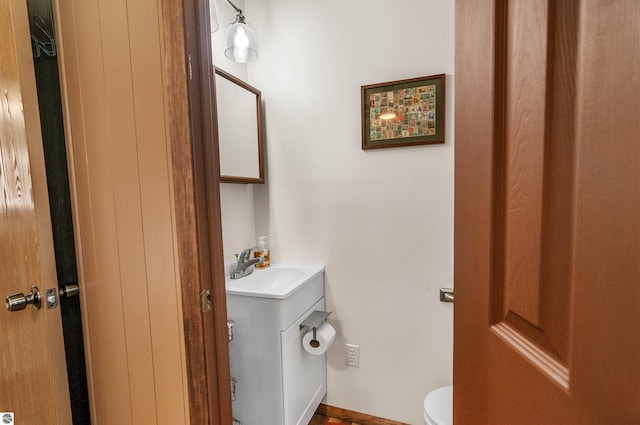 half bathroom featuring vanity and toilet