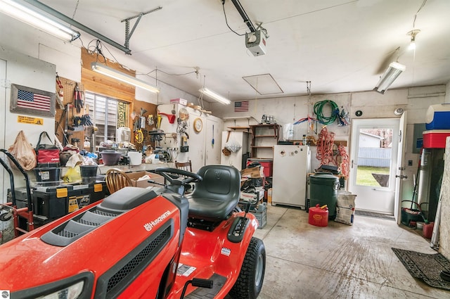 garage featuring visible vents, freestanding refrigerator, and a garage door opener