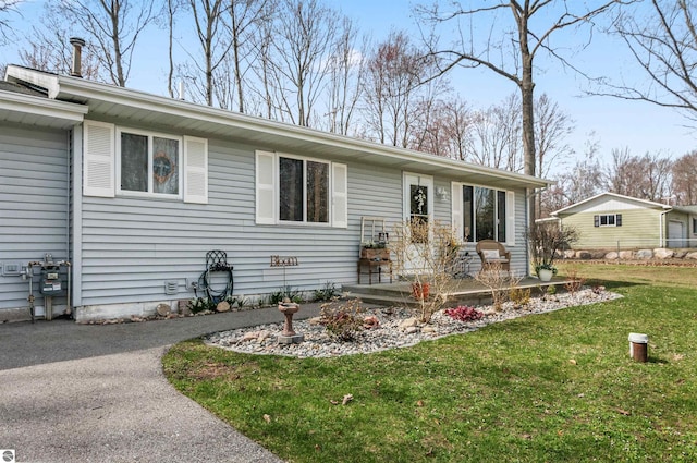 single story home with aphalt driveway and a front yard