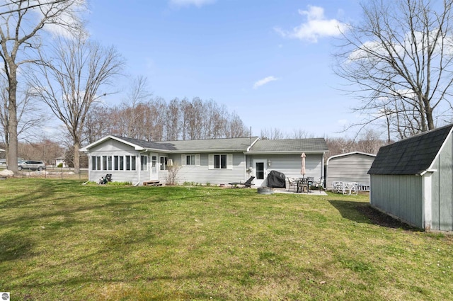 back of house featuring an outbuilding, a storage unit, a lawn, and entry steps