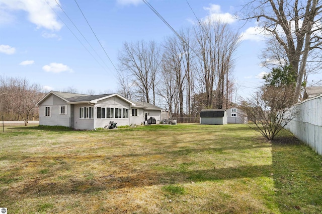 view of yard featuring an outdoor structure, a shed, and fence