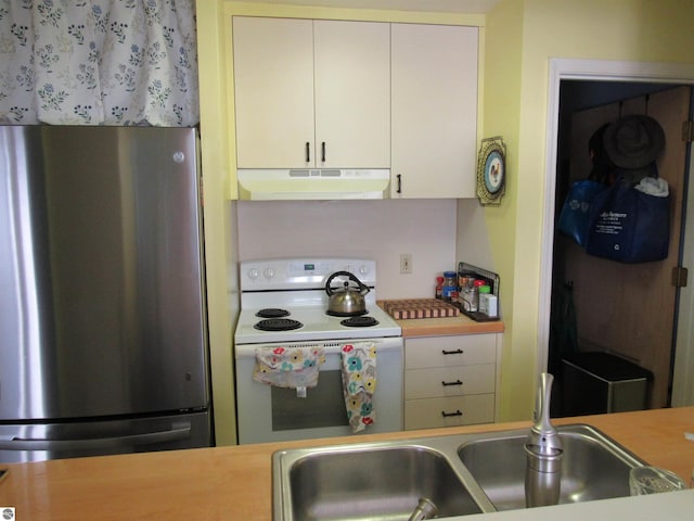 kitchen with white electric stove, light countertops, freestanding refrigerator, and under cabinet range hood