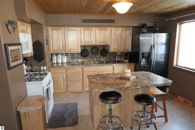 kitchen featuring wooden ceiling, light brown cabinets, white appliances, a kitchen island, and a sink