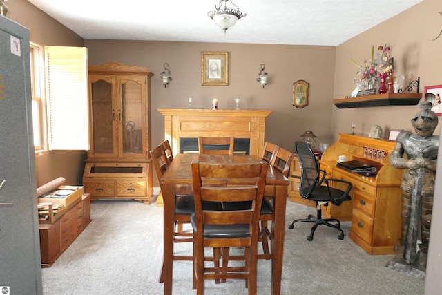 dining room with light carpet and a fireplace