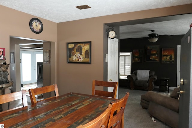 dining room with carpet floors, a ceiling fan, a textured ceiling, and french doors