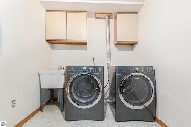 washroom featuring cabinet space, baseboards, and independent washer and dryer