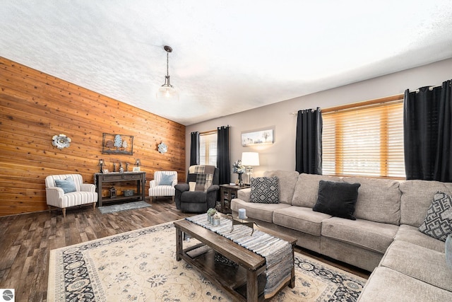 living area featuring a fireplace, wood walls, a textured ceiling, and wood finished floors