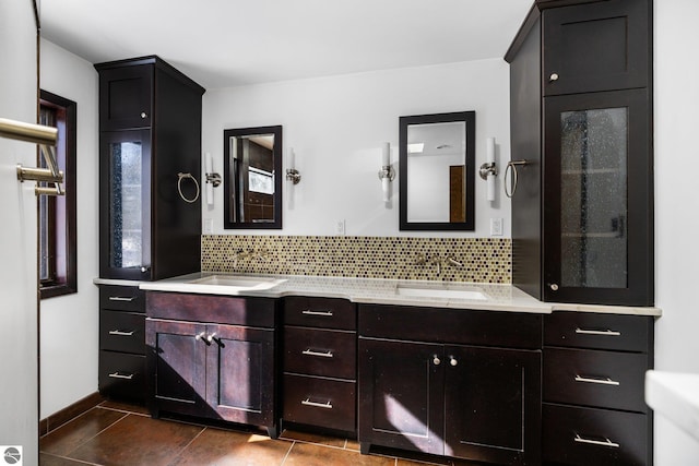 bathroom with double vanity, tile patterned flooring, a sink, and backsplash