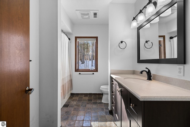 full bath featuring toilet, stone finish flooring, visible vents, and vanity