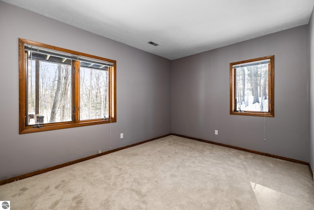 unfurnished room featuring light carpet, visible vents, and baseboards