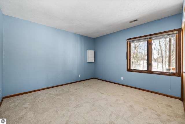 unfurnished room featuring baseboards, visible vents, a textured ceiling, and light colored carpet