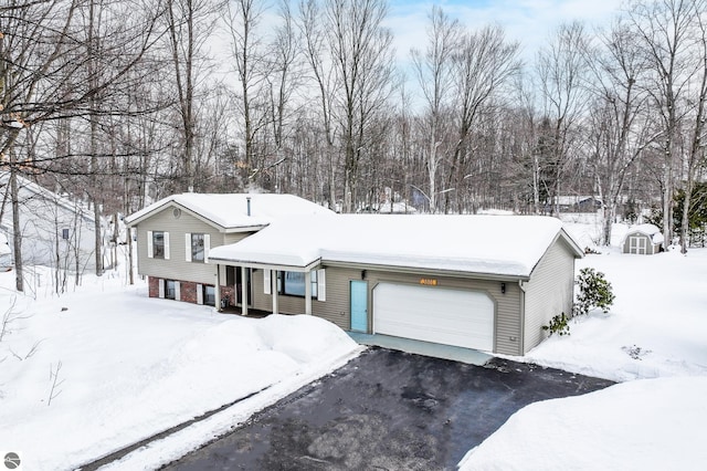 tri-level home with aphalt driveway, brick siding, and an attached garage