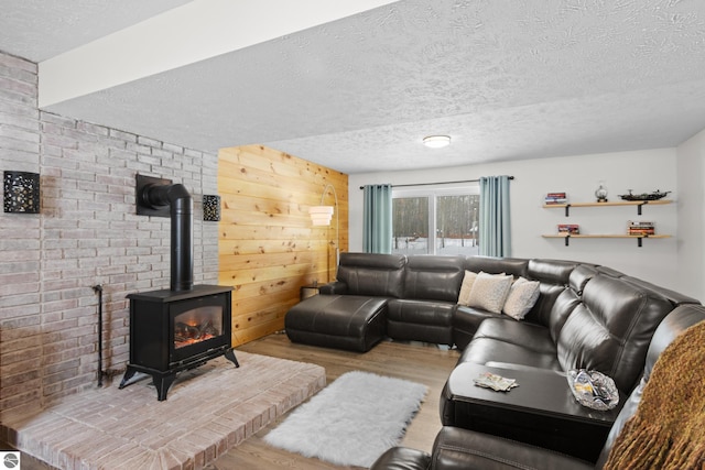 living room featuring a textured ceiling, light wood-style flooring, and a wood stove