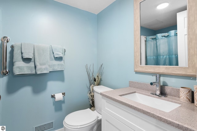 bathroom featuring visible vents, vanity, and toilet