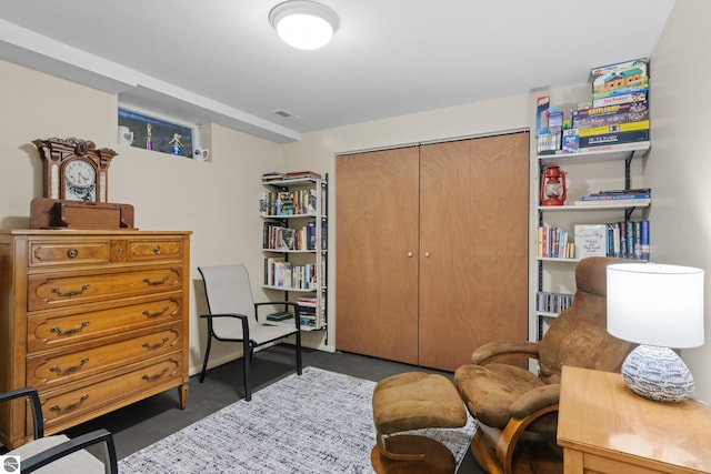 living area featuring concrete flooring and visible vents