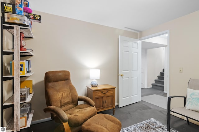 living area featuring stairway and baseboards