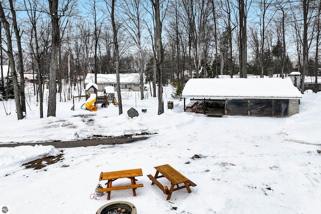 snow covered rear of property featuring a playground