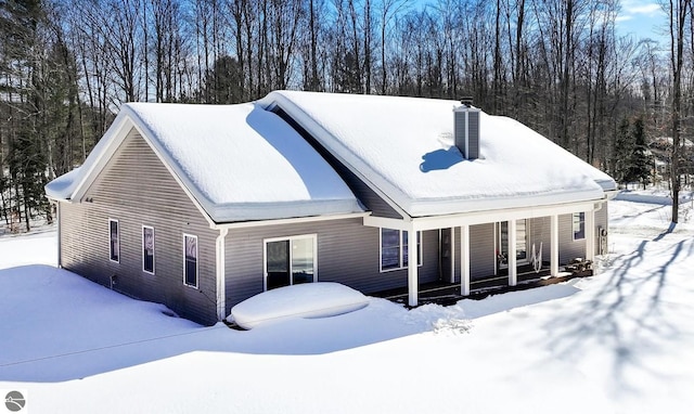 view of front of home featuring covered porch and a chimney