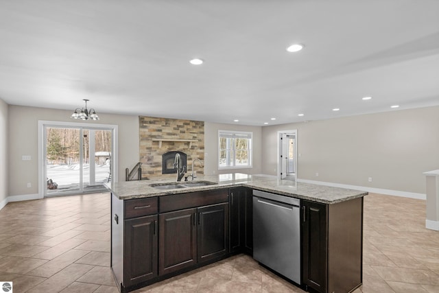 kitchen featuring light stone counters, recessed lighting, open floor plan, a sink, and dishwasher