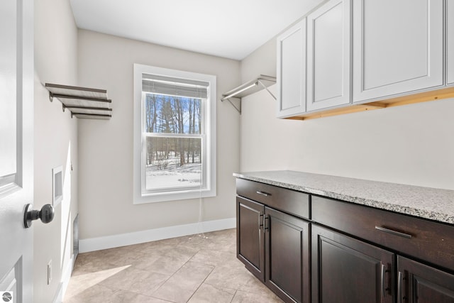 washroom featuring cabinet space and baseboards